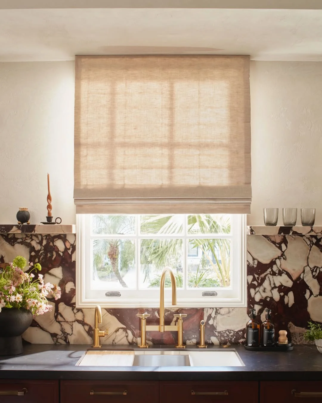 Beige linen roman shade on a kitchen window