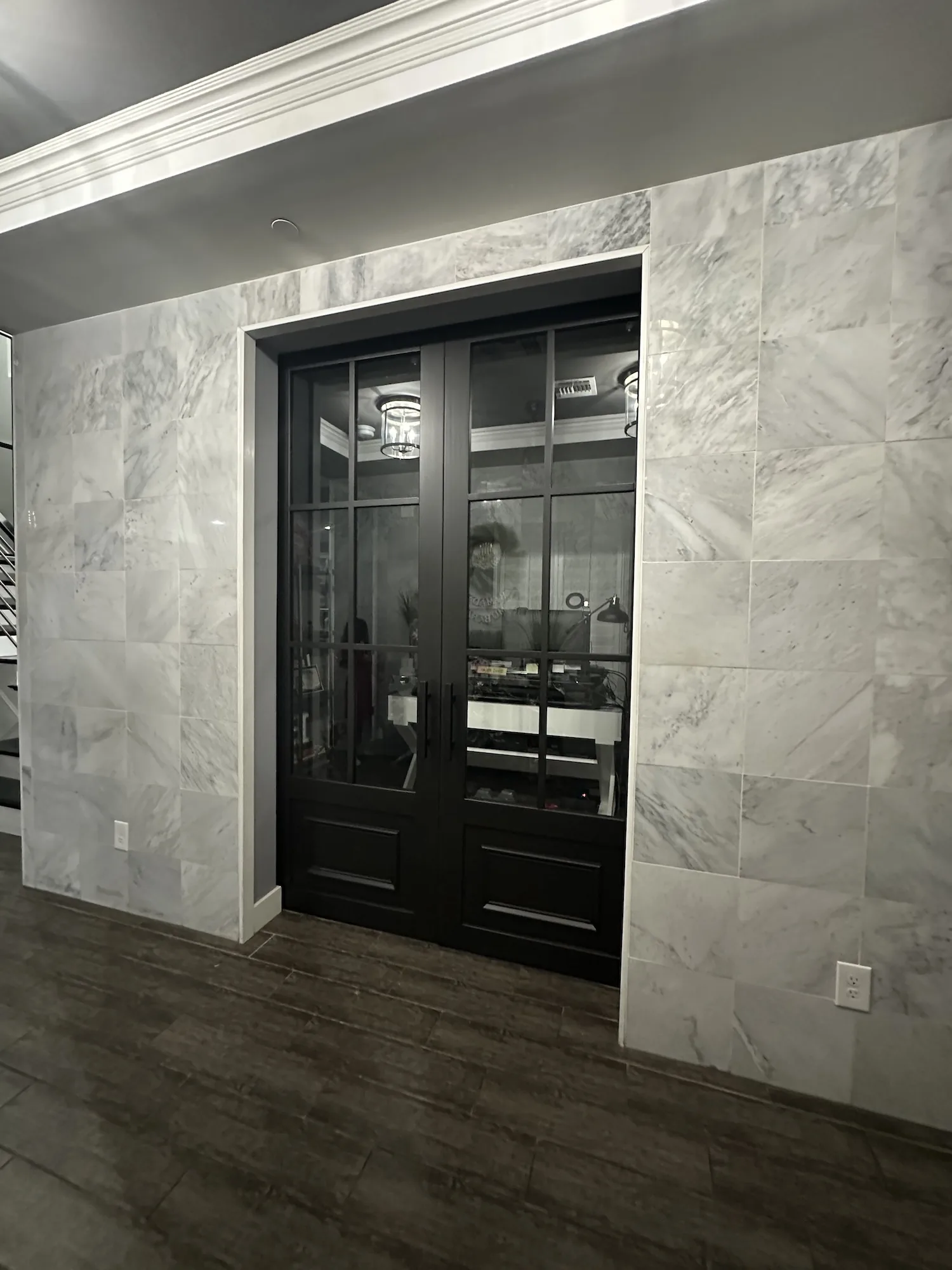 Black French Lite double slider barn doors framing a marble entry