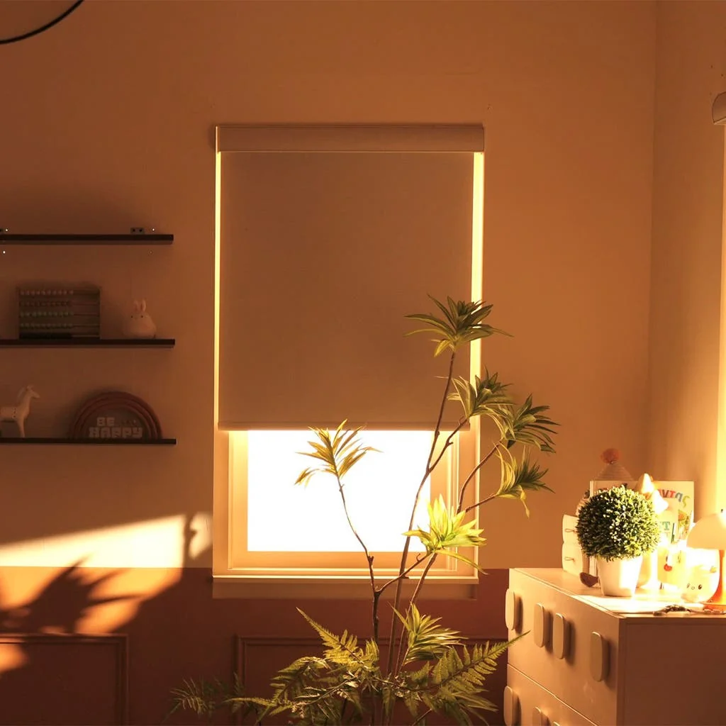 Motorized blackout roller shade lowering at sunset