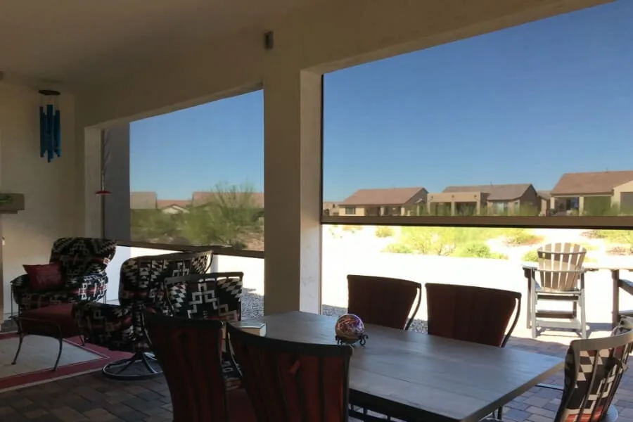 Desert Dining View, two shaded bays over a patio dining table with the desert and neighbouring rooftops visible through the mesh