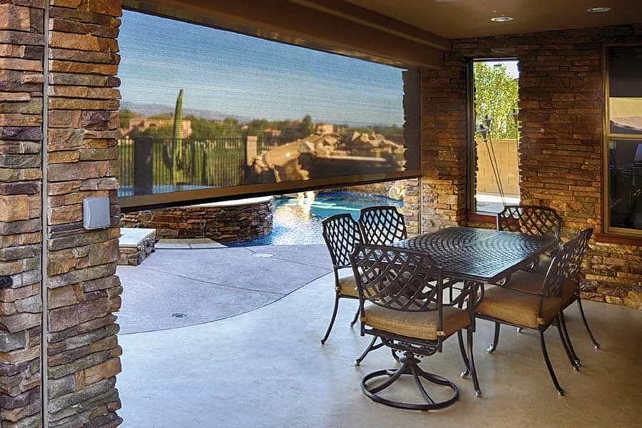 See Straight Through, the view from inside a shaded patio looking out through the mesh to a pool, rock feature, and saguaro