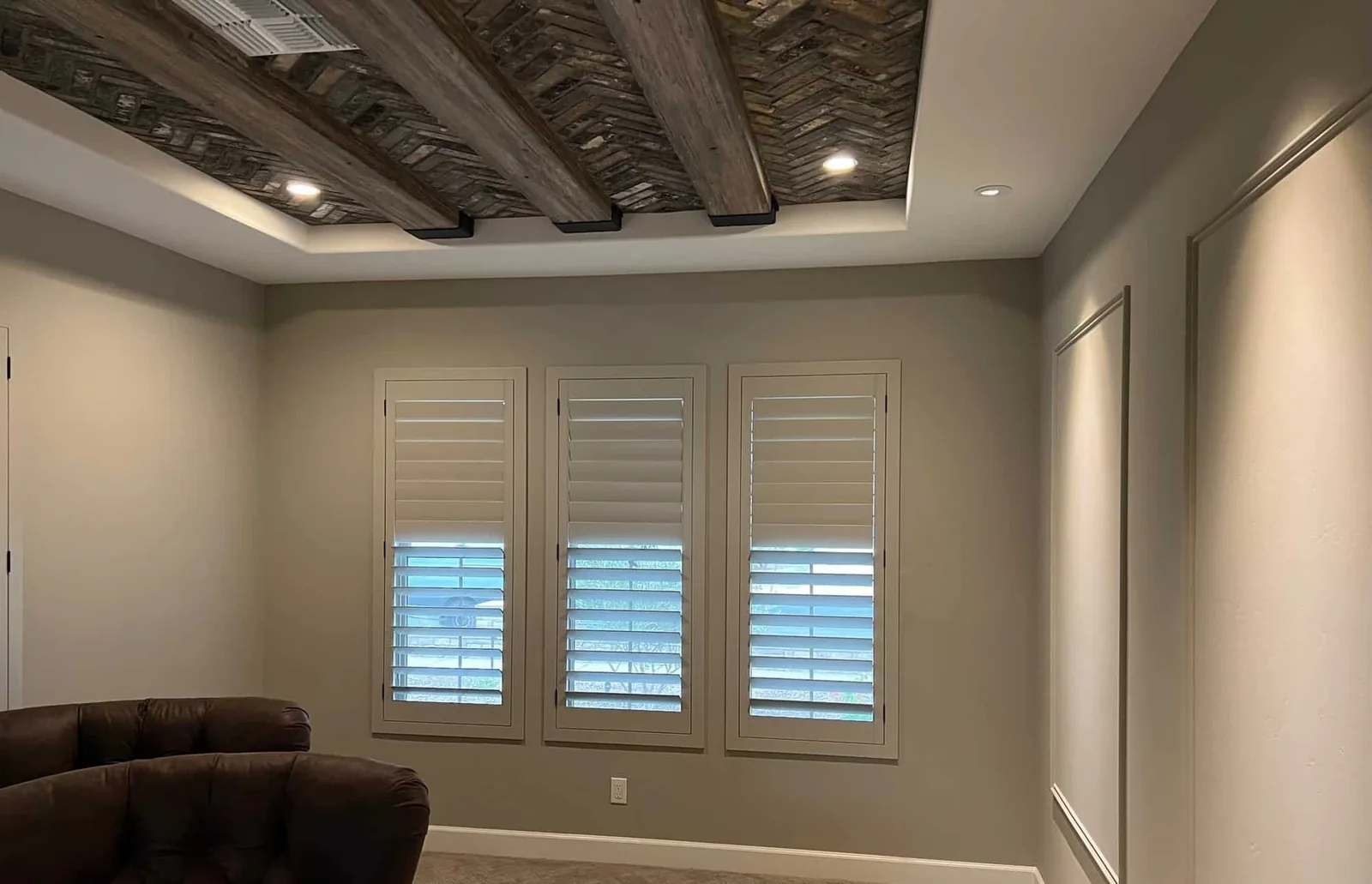 Plantation shutters under a wood-beam ceiling