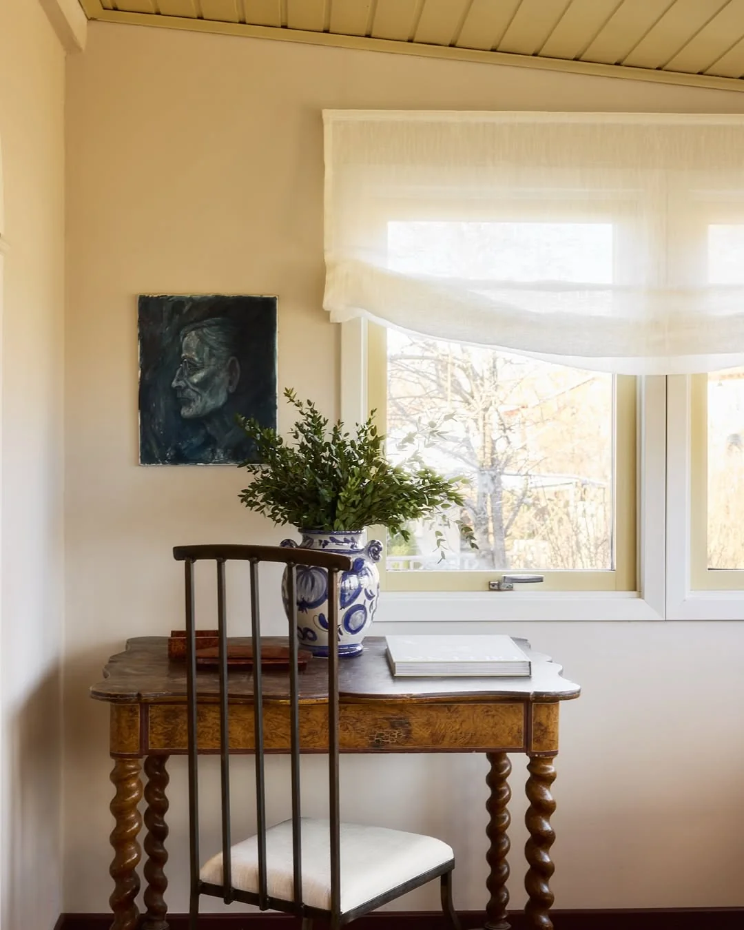 Sheer linen relaxed roman shade in a study