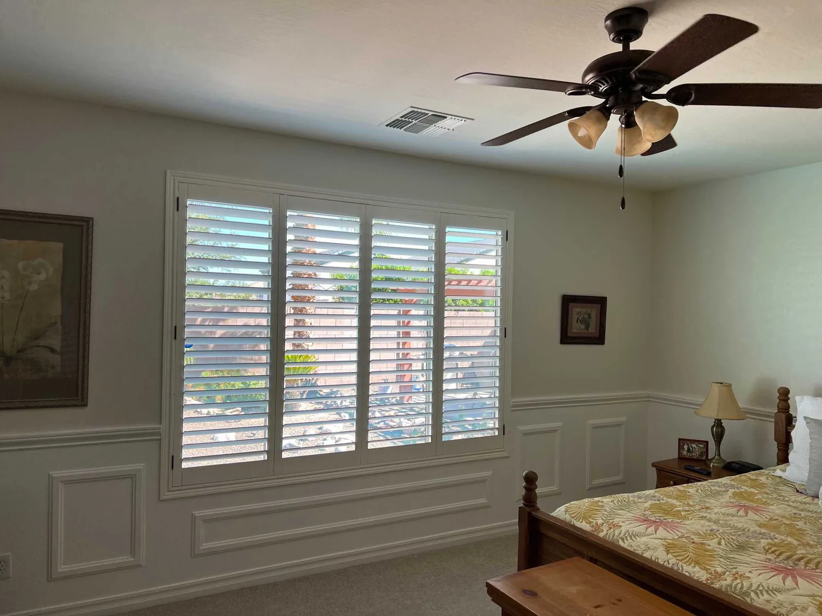 White plantation shutters on a bedroom's triple window